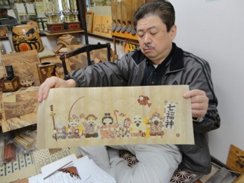 “The Seven Gods of Fortune”. This artwork is a combination of both Yosegi Zaiku wood mosaic and Moku Zougan inlaid woodwork.